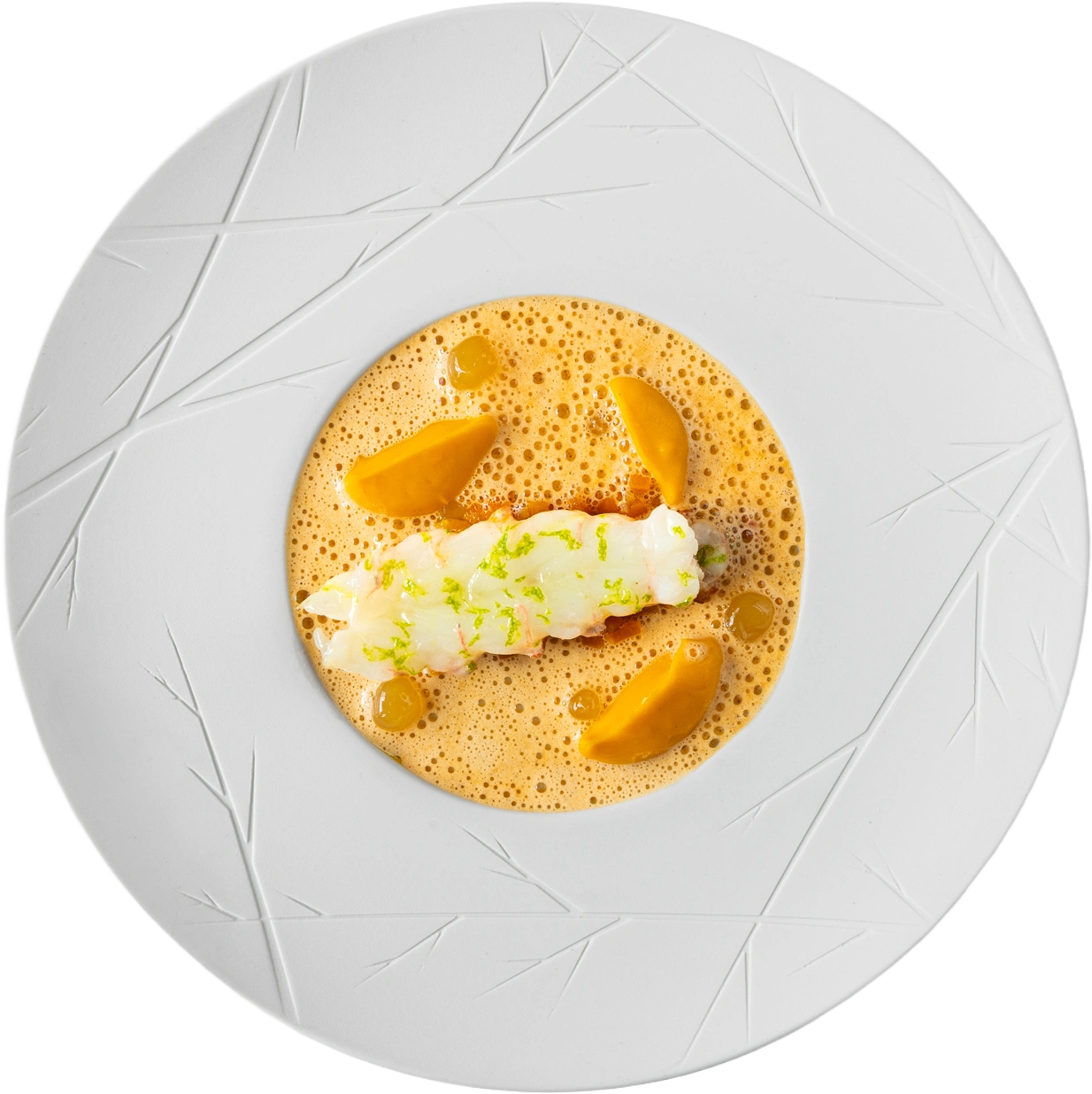Langoustinestaart met limoenrasp in schuimende bisque, quenelles saffraangele purée, op wit reliëfbord