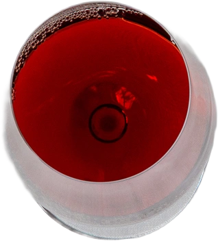 Wijnglas met rode wijn, van bovenaf, belletjes langs de rand.